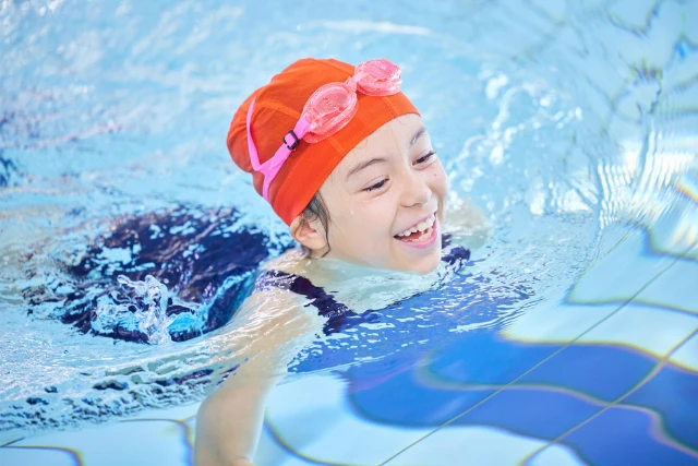A child smiles swimming in a pool